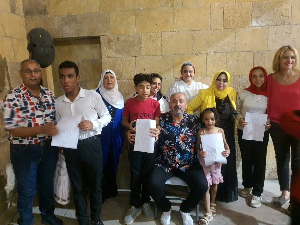 الفنان خالد كامل يتوسط الأطفال في إحدى الفعاليات الفنية السابقة