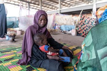 أم تعتني بطفلها في مخيم للنازحين في السودان. © UNOCHA/Giles Clarke