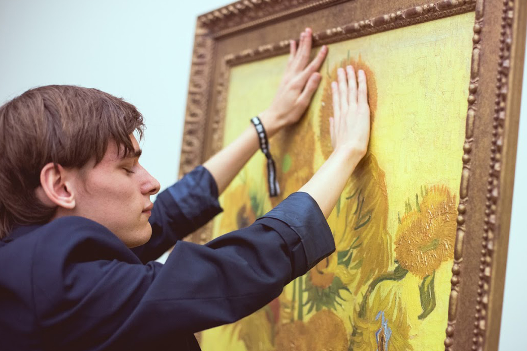 رجل كفيف يعاين إحدى اللوحات بيديه