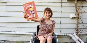 ريبيكا توسيج تحمل كتابها Sitting Pretty