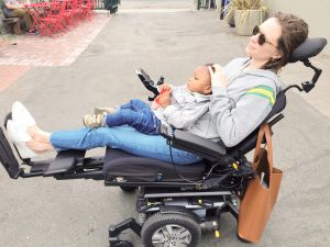 جيسيكا سلايس فوق كرسيها المتحرك وهي تحمل طفلتها