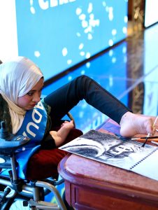 إحدى خريجات أكاديمية حلم تستعرض قدرتها على الكتابة بساقها