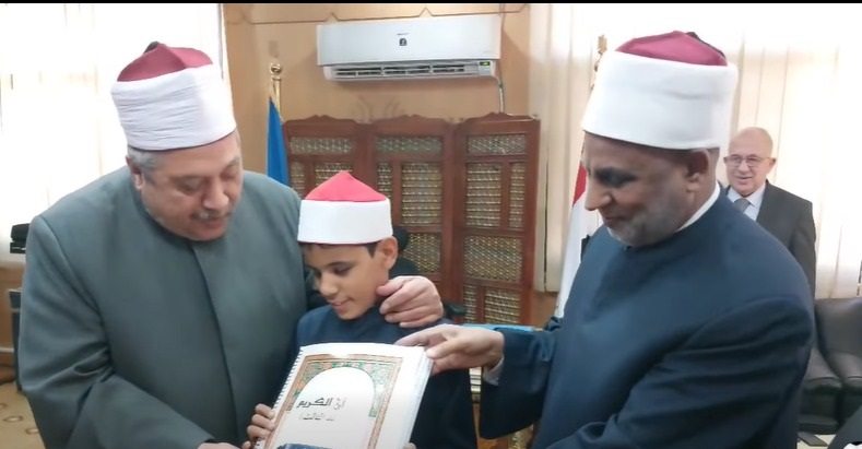 مصحف مطبوع بطريقة برايل وشهادة تقدير للطالب عمر أحمد محمد