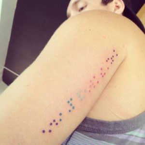 شخص نقش بشكل بارز وشم برايل على ذراعه